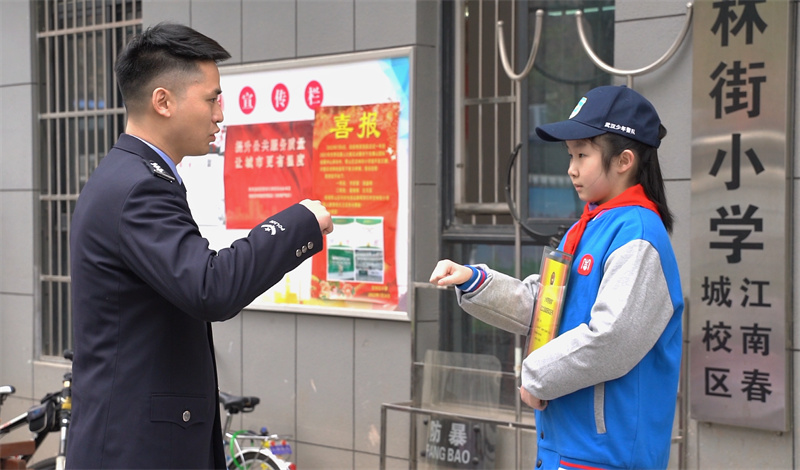 民警和孩子碰拳約定。