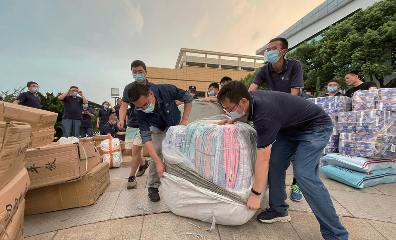 疫情期間，黨員干部沖在前面為員工搬運生活物資。王子維攝