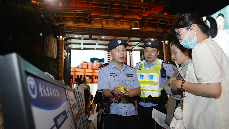 7月7日小暑時(shí)節(jié)，武昌區(qū)公安分局漢街派出所民警冒著夏日的炎炎高溫在漢街大戲臺(tái)向來(lái)往游客宣傳防騙禁毒知識(shí)。孫遜攝