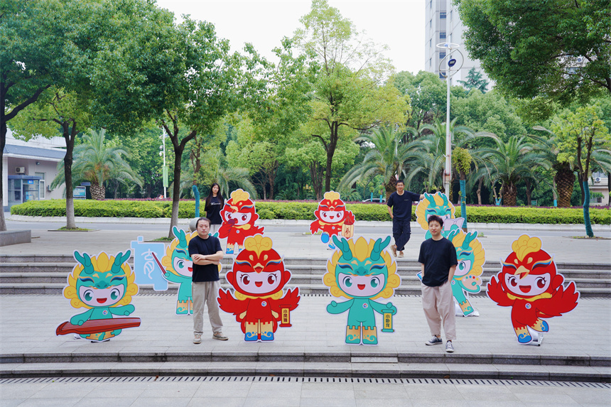 師生創(chuàng)作團(tuán)隊(duì)部分成員與卡通形象“小臥龍”“小鳳雛”合影