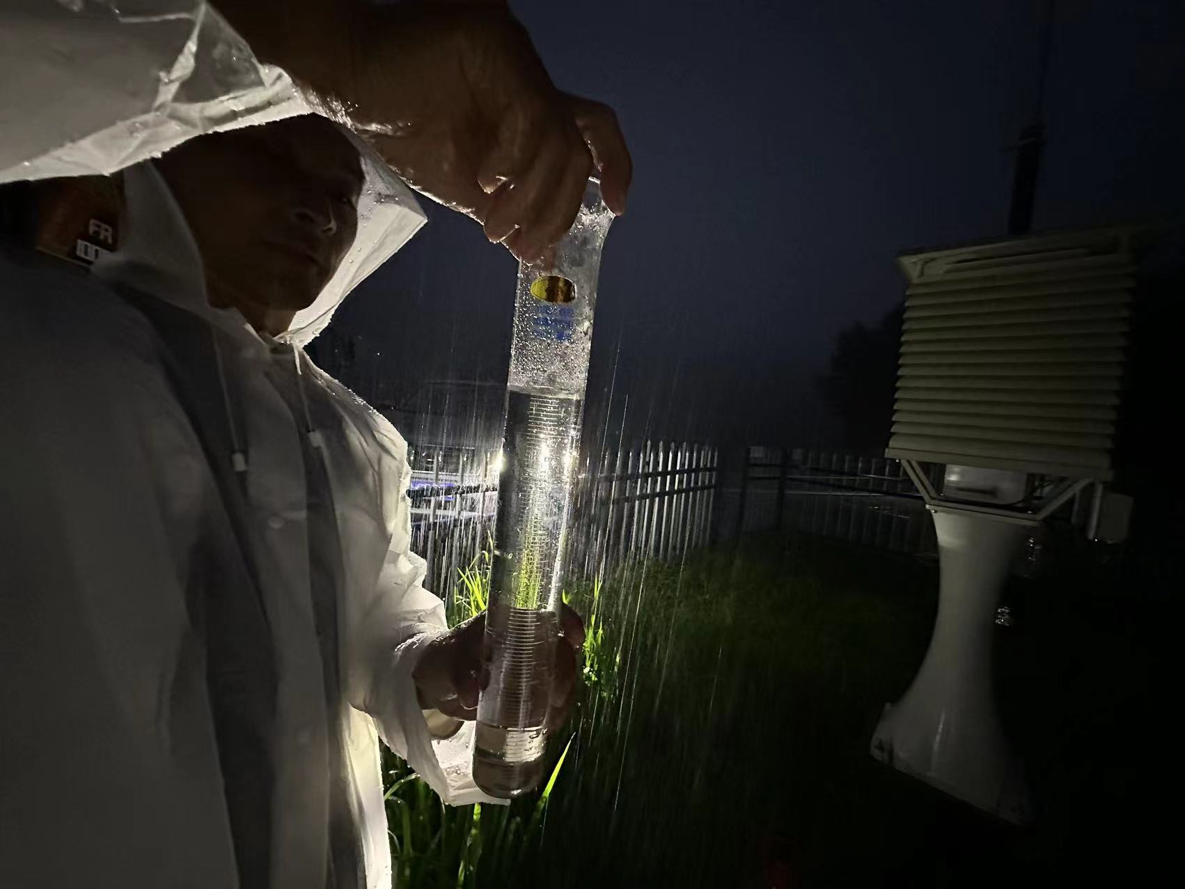 氣象觀測員雨夜核查觀測站降水量。朱慧麗攝