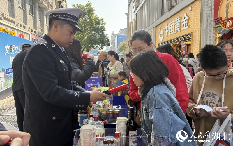 市民在拒絕酒駕體驗(yàn)攤位對(duì)著酒精檢測(cè)儀吹氣。人民網(wǎng)記者 周恬